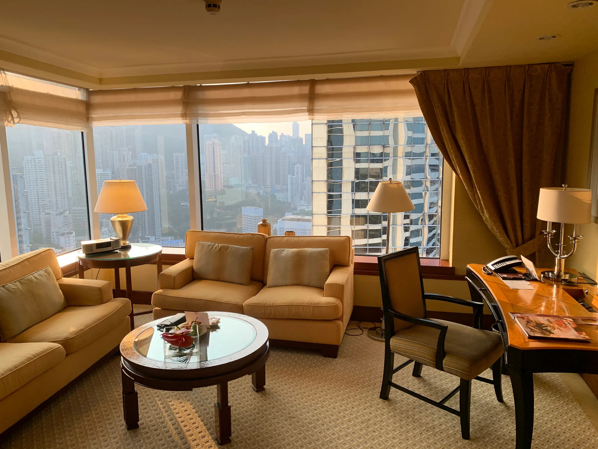 Hotelzimmer mit Sessel, Couch und Tisch vor Panoramafenster