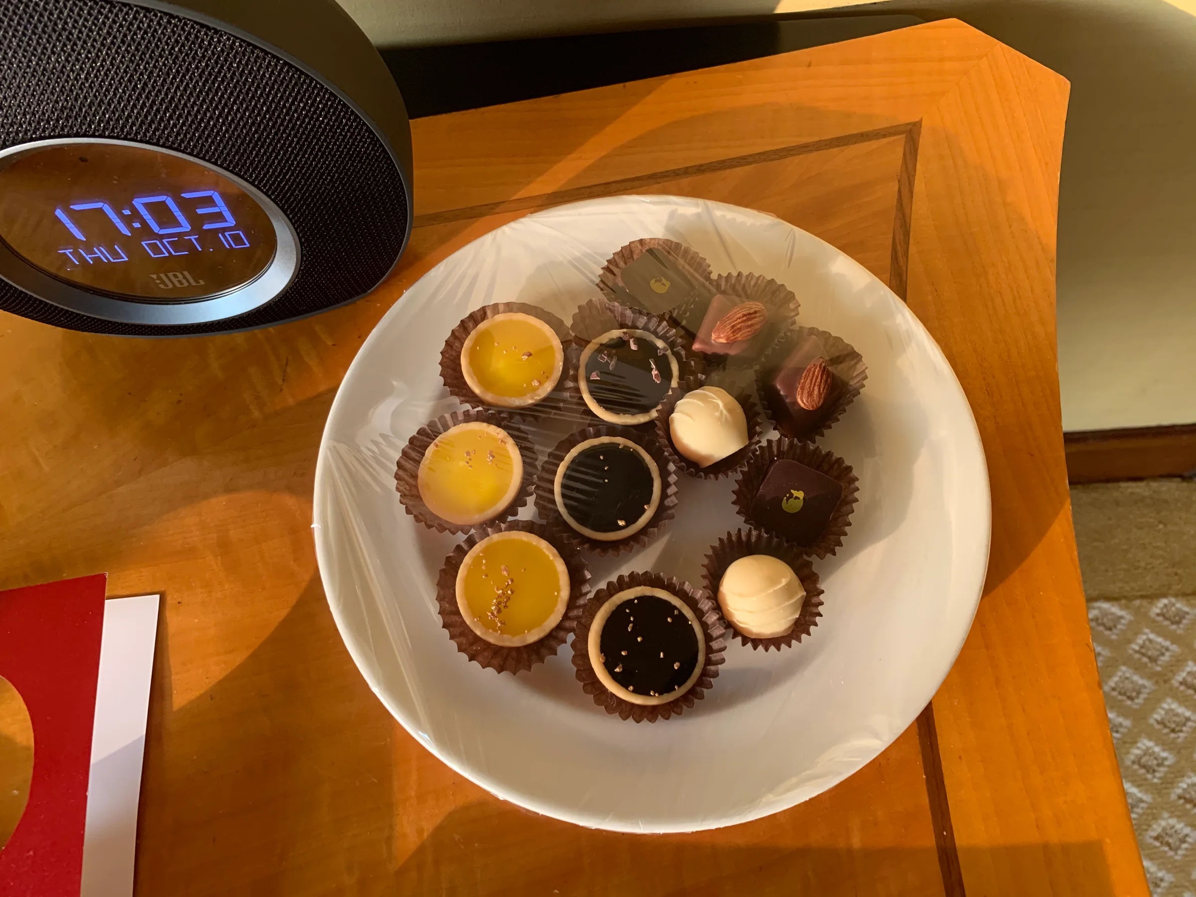 Schokoladenpralinen auf Teller vor Wecker