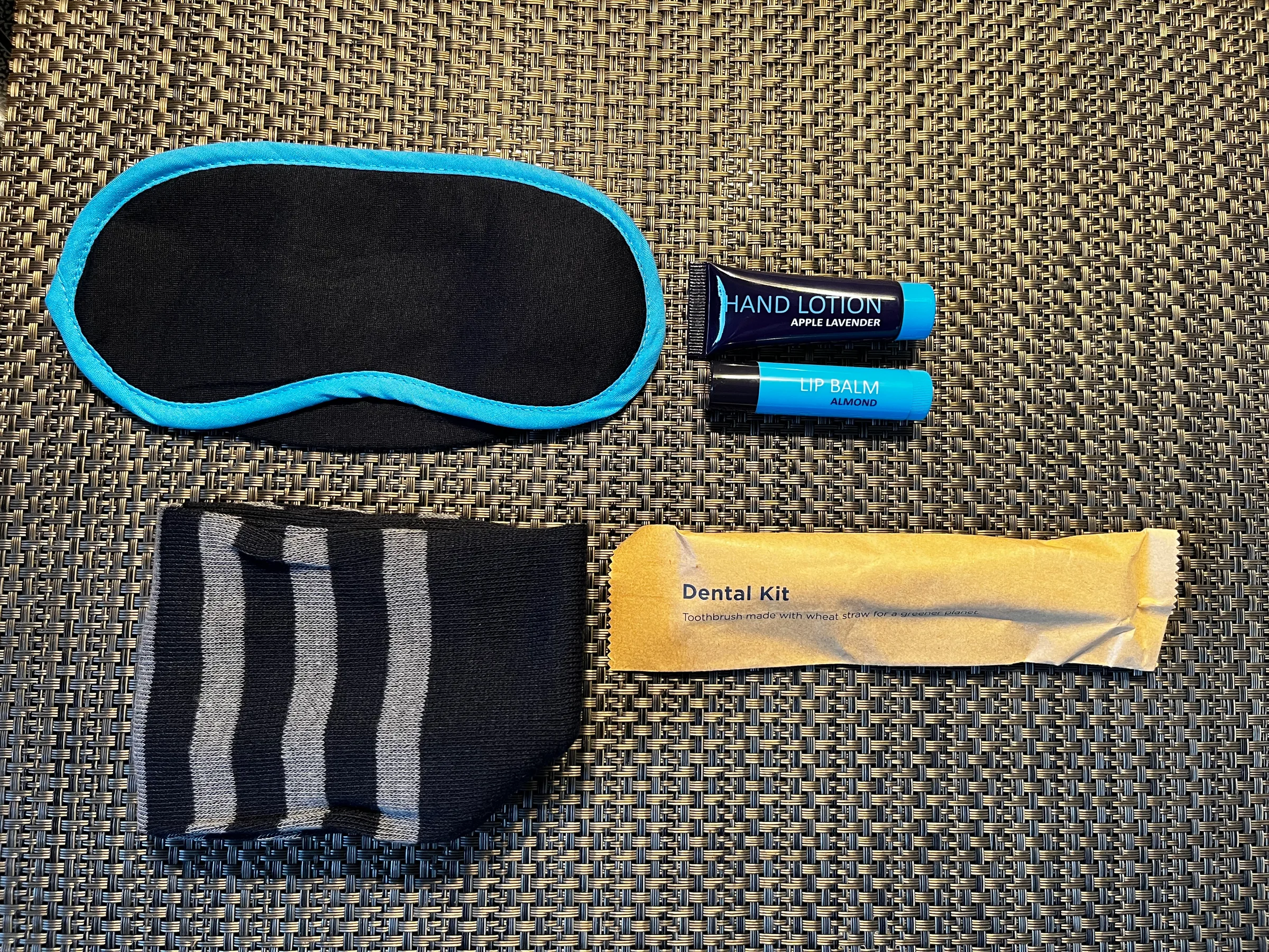 Inhalt ausgebreitet: Schlafmaske, Lippenbalsam und Zahnpflege