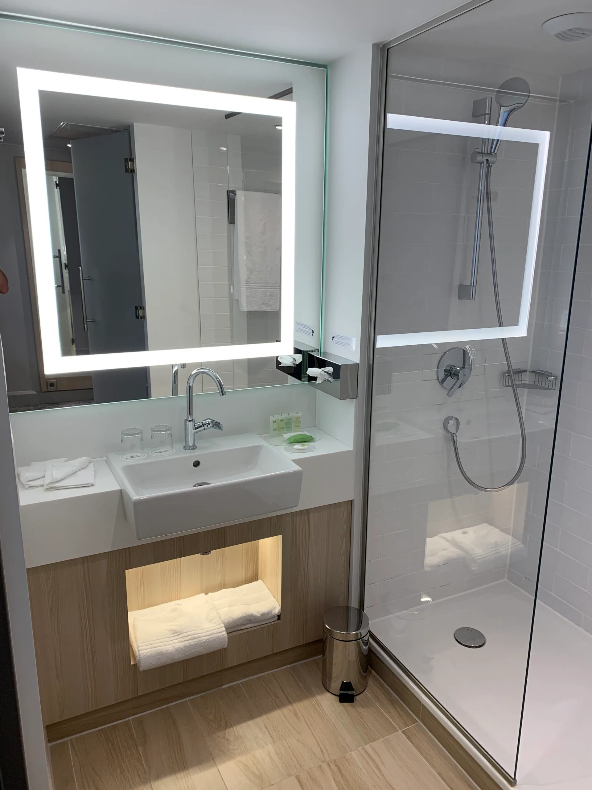 Moderne Hotel-Duschbad mit Spiegelschrank und integriertem Handtuchhalter