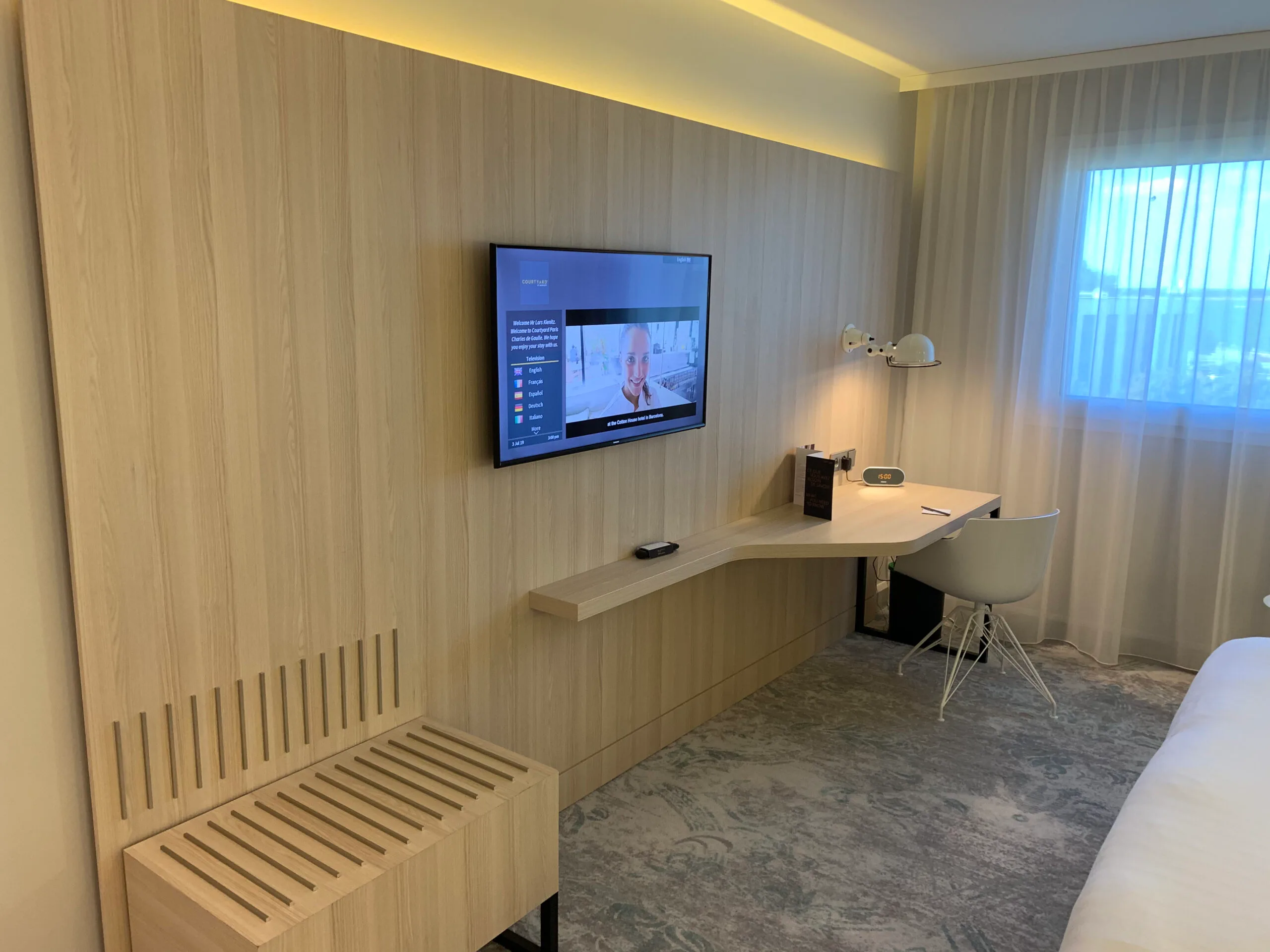 Hotelzimmer mit Holzwand, TV und Schreibtisch