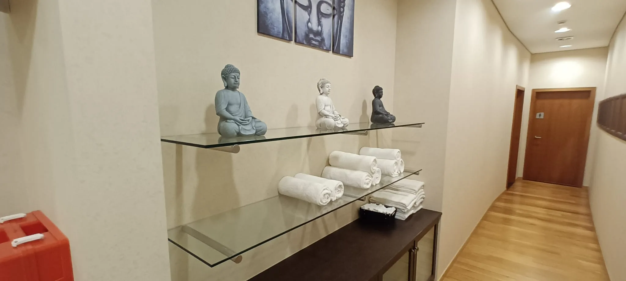 Wandregal mit Buddha-Statuen und Handtüchern im Flur eines Hotels