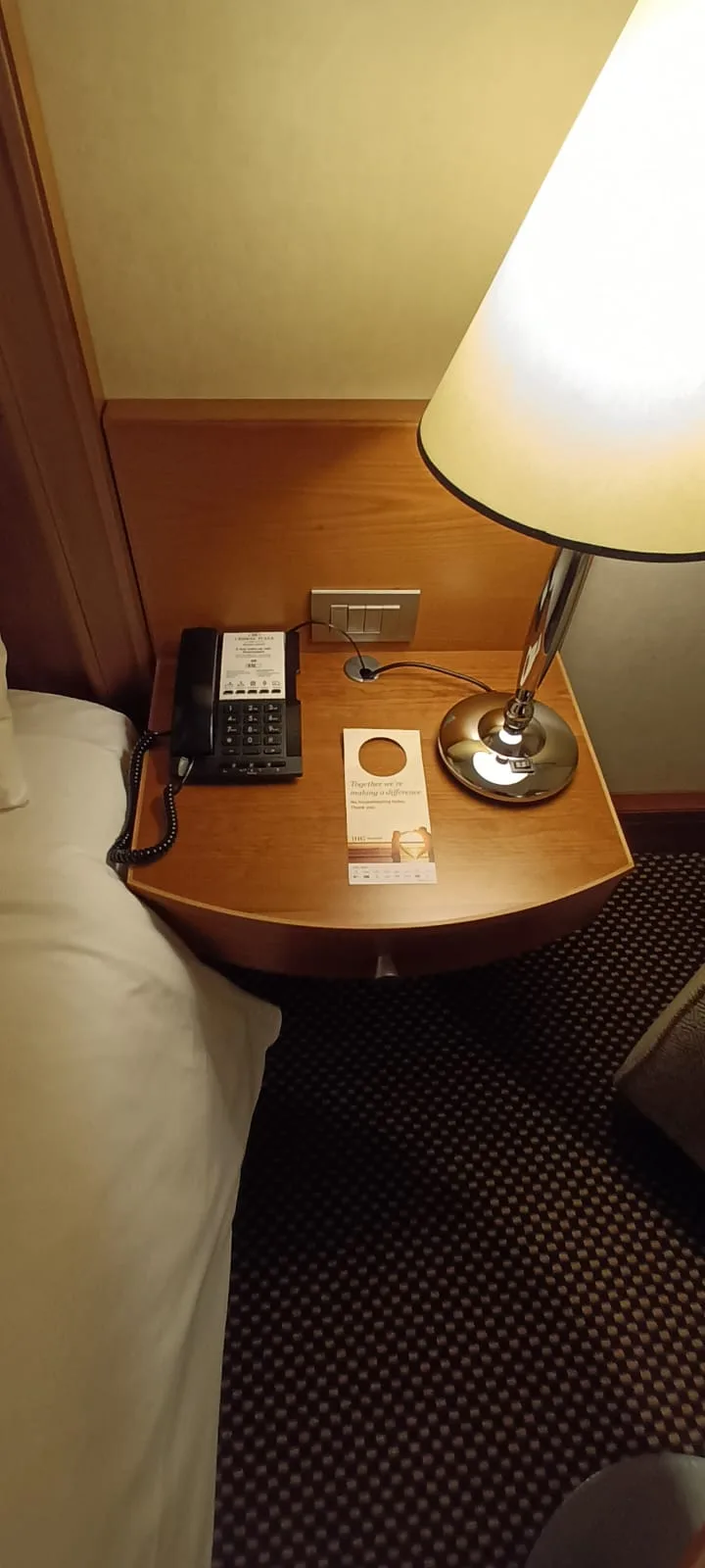 Hotelnachttisch mit Telefon und Lampe