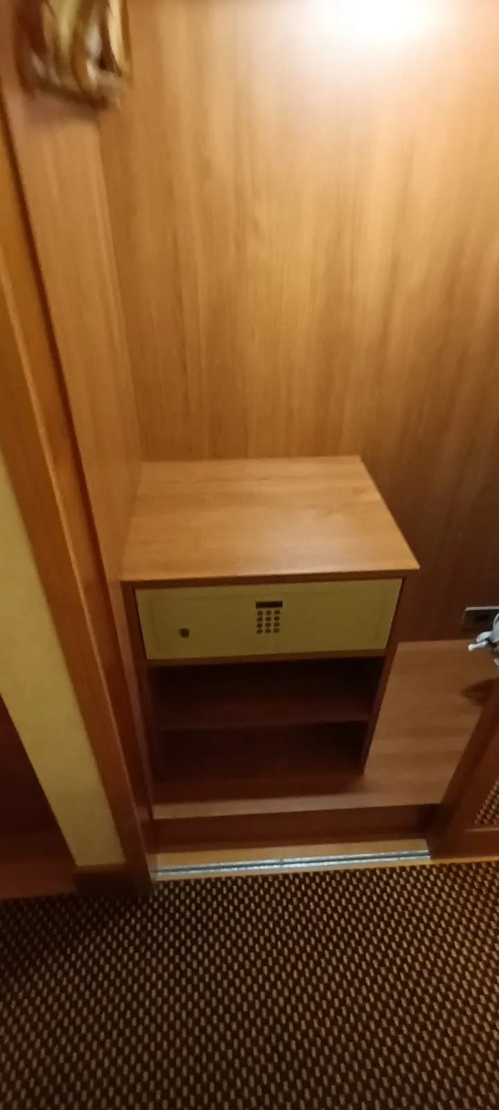 Holzregal mit Schließfach in einem Hotelzimmer
