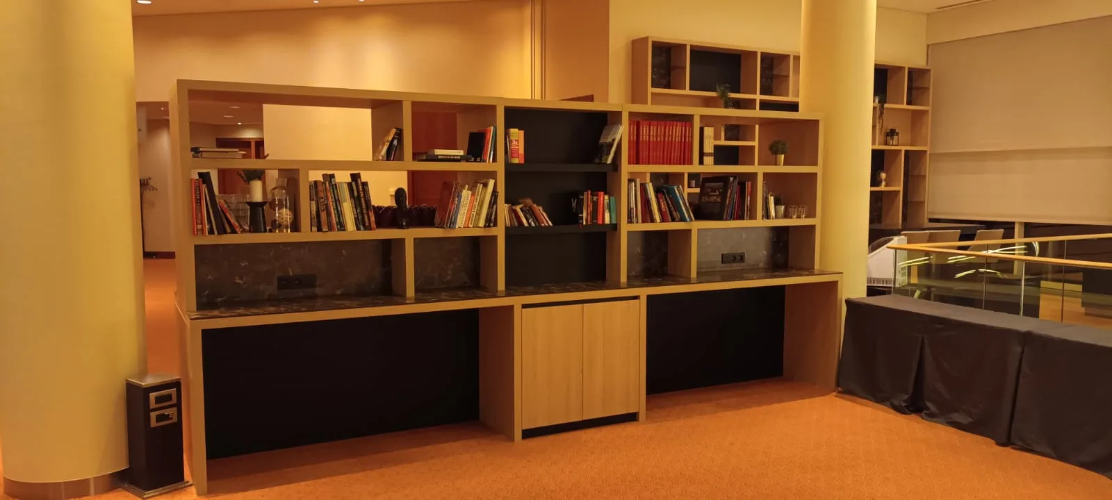 Holzregal mit Büchern und Dekorationen im Hotellobby