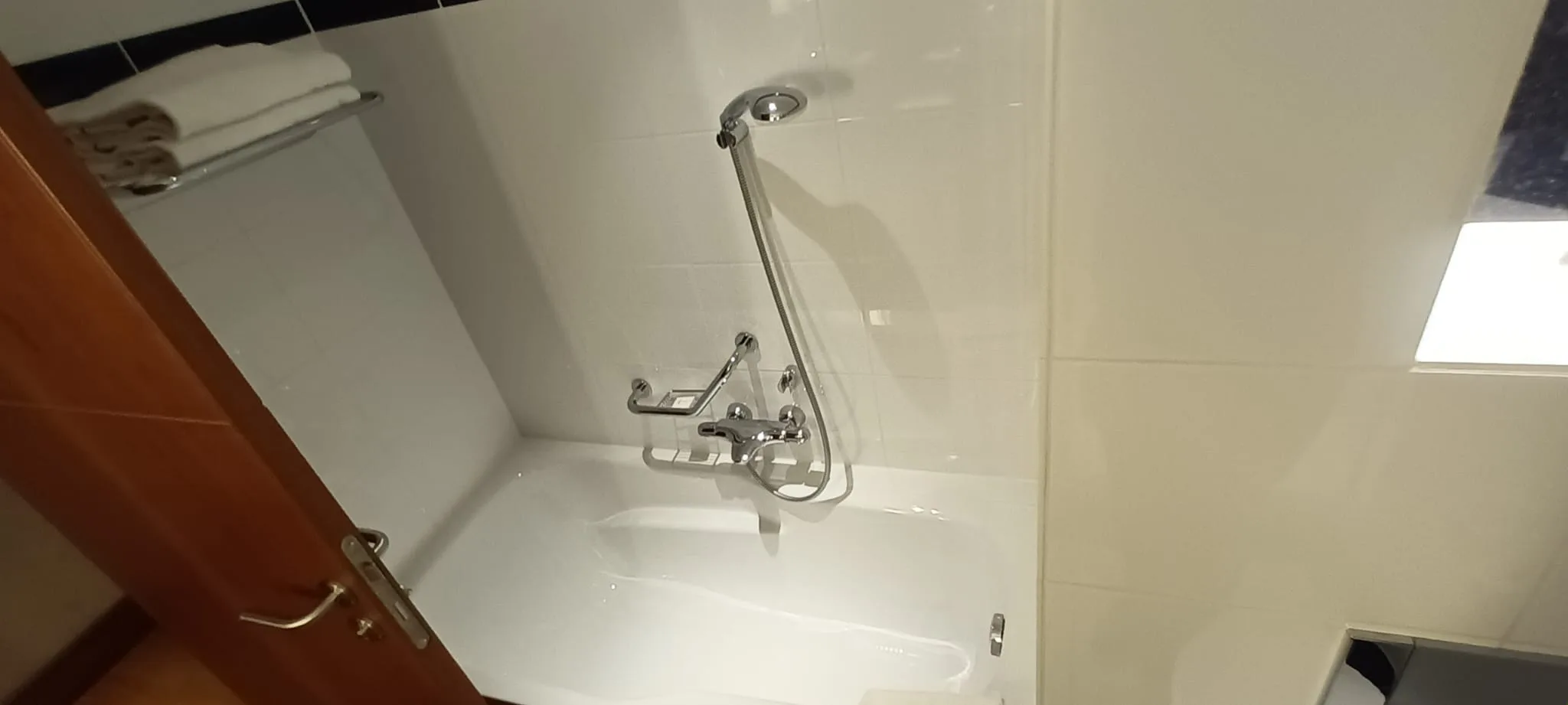 Moderne Badezimmer-Dusche mit Handbrause und Regal