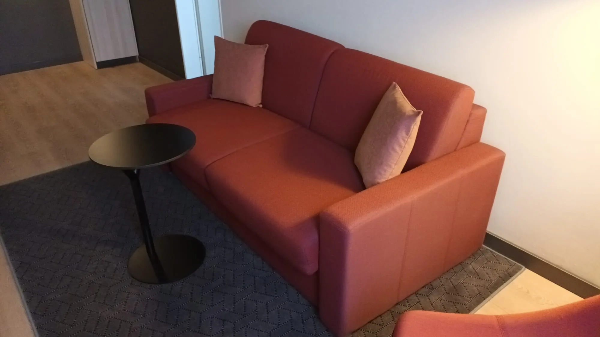 rote Couch mit Kissen im Hotelzimmer