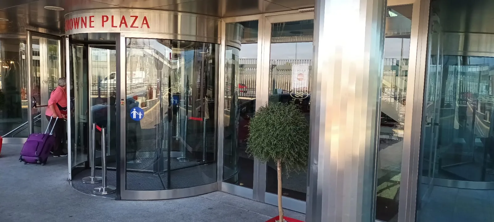 Drehende Eingangstür eines Hotels mit Schild 'Crowne Plaza'