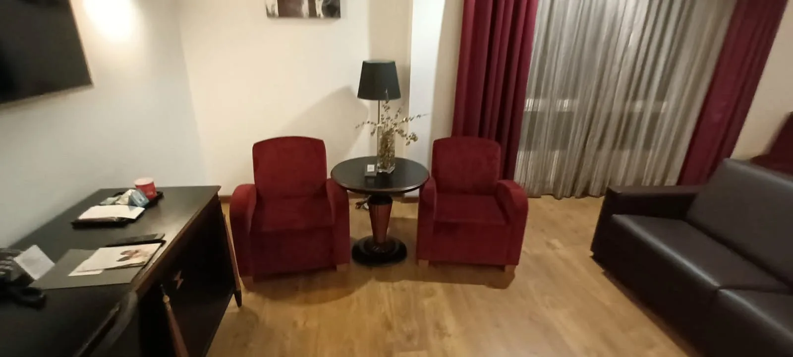 Hotelzimmer mit roten Sesseln und Couch