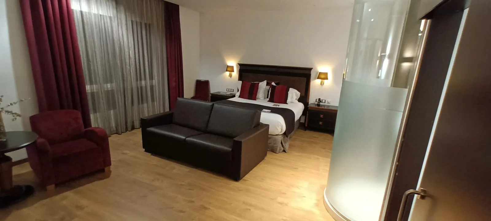 Hotelzimmer mit Doppelbett und Couch in Grautönen