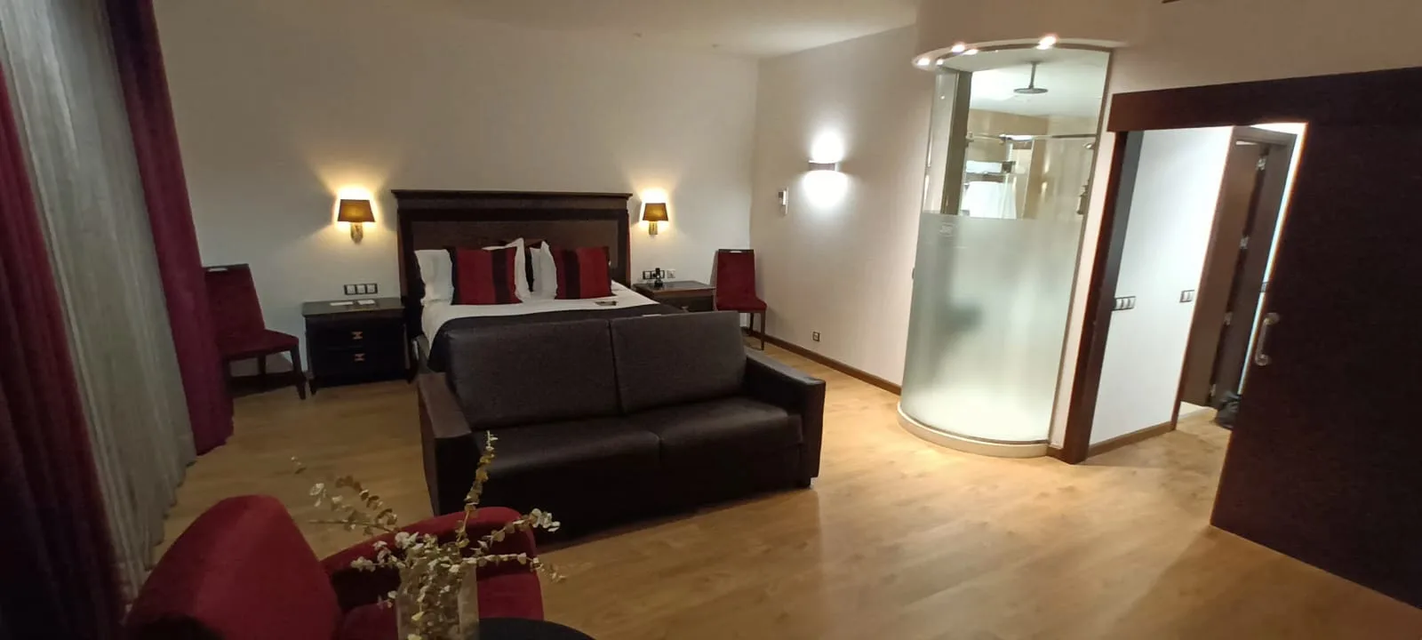 Hotelzimmer mit Doppelbett und Couch in Grautönen