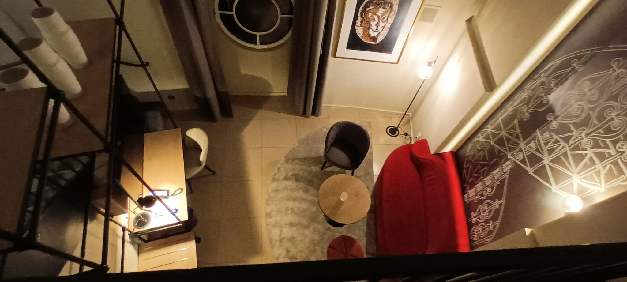 Hotelzimmer mit rotem Sofa und runder Couchtisch im Treppenhaus
