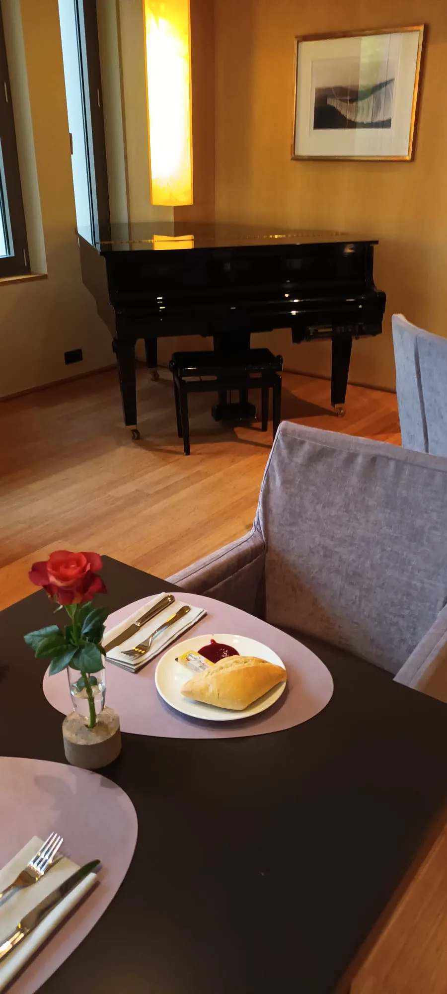 Hotelzimmer mit Klavier und Essbereich