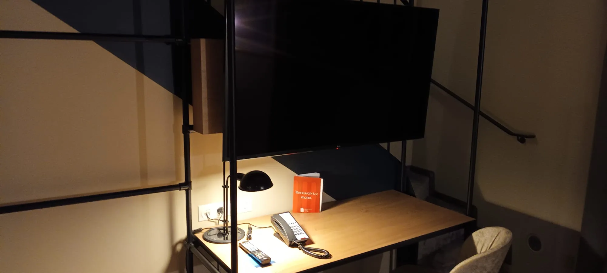 Hotelzimmer mit Schreibtisch, Telefon und Fernbedienung