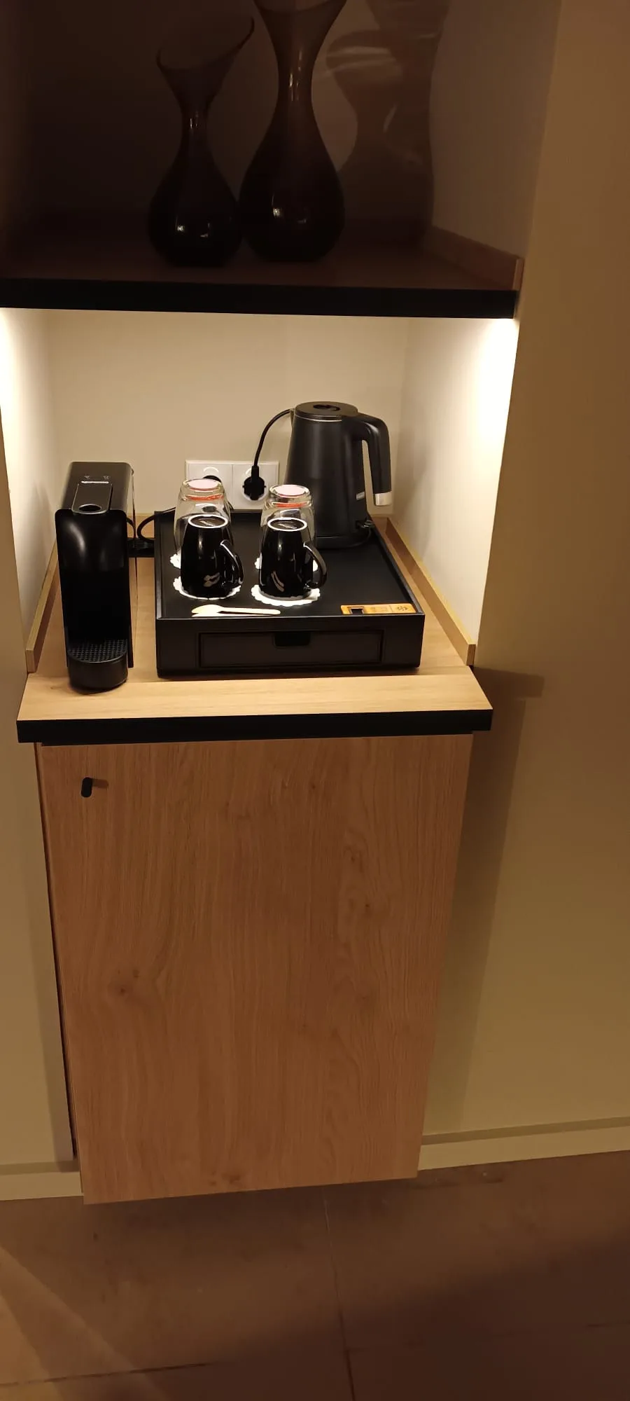 Hotelkaffeebereich mit Kaffeemaschine und Tassen auf Holztisch