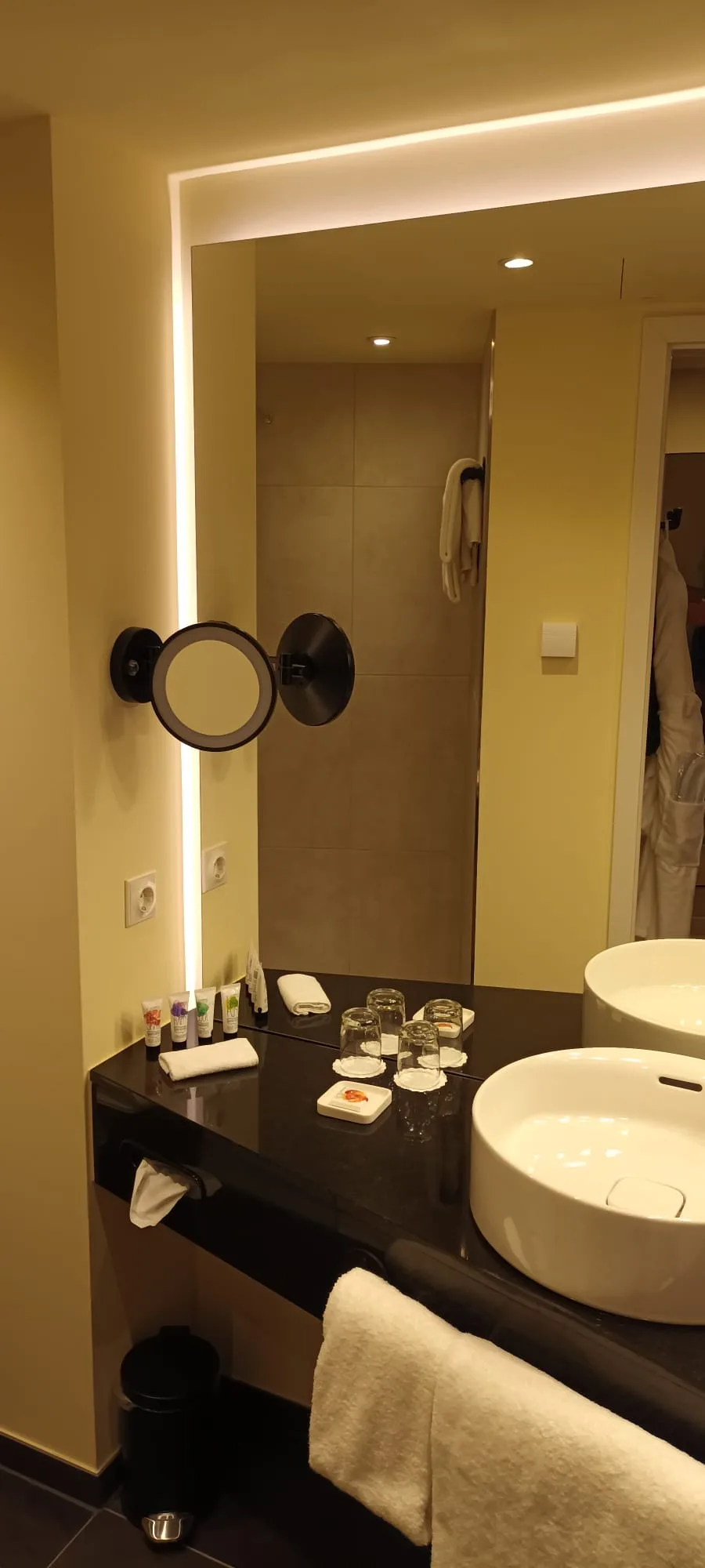 Hotelbadezimmer mit Spiegel, Waschbecken und Kosmetikset