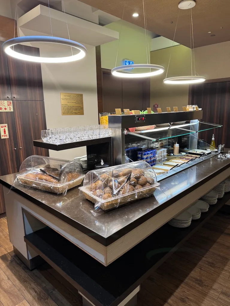 Frühstücksbuffet mit Gebäck und Getränken in einem Flughafenlounge