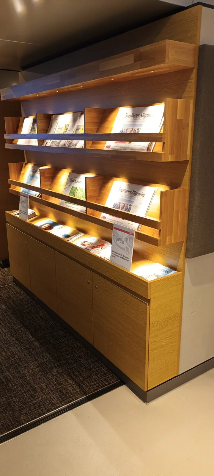 Holzregal mit Zeitungen und Zeitschriften im DB Lounge Frankfurt Flughafen