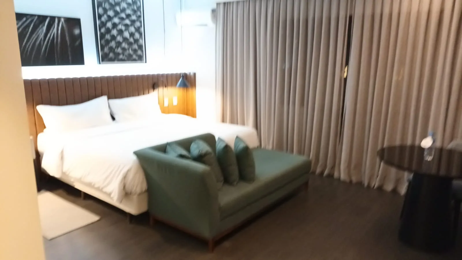 Hotelzimmer mit Doppelbett und Sessel in Grautönen