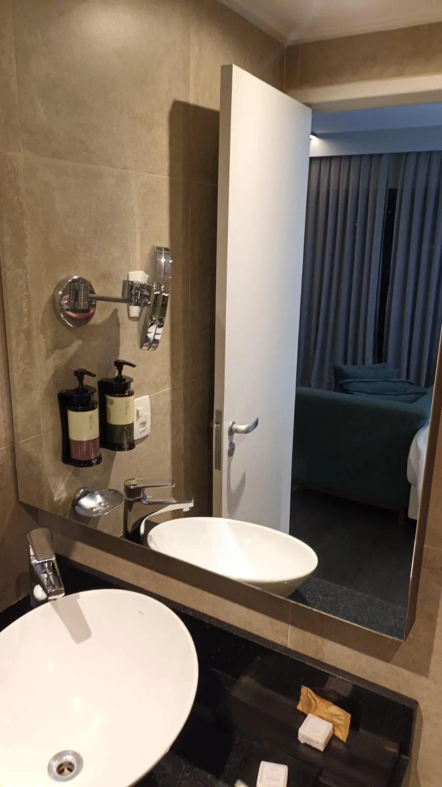 Doppeltes Waschbecken mit Spiegel und Kosmetikflaschen im Badezimmer