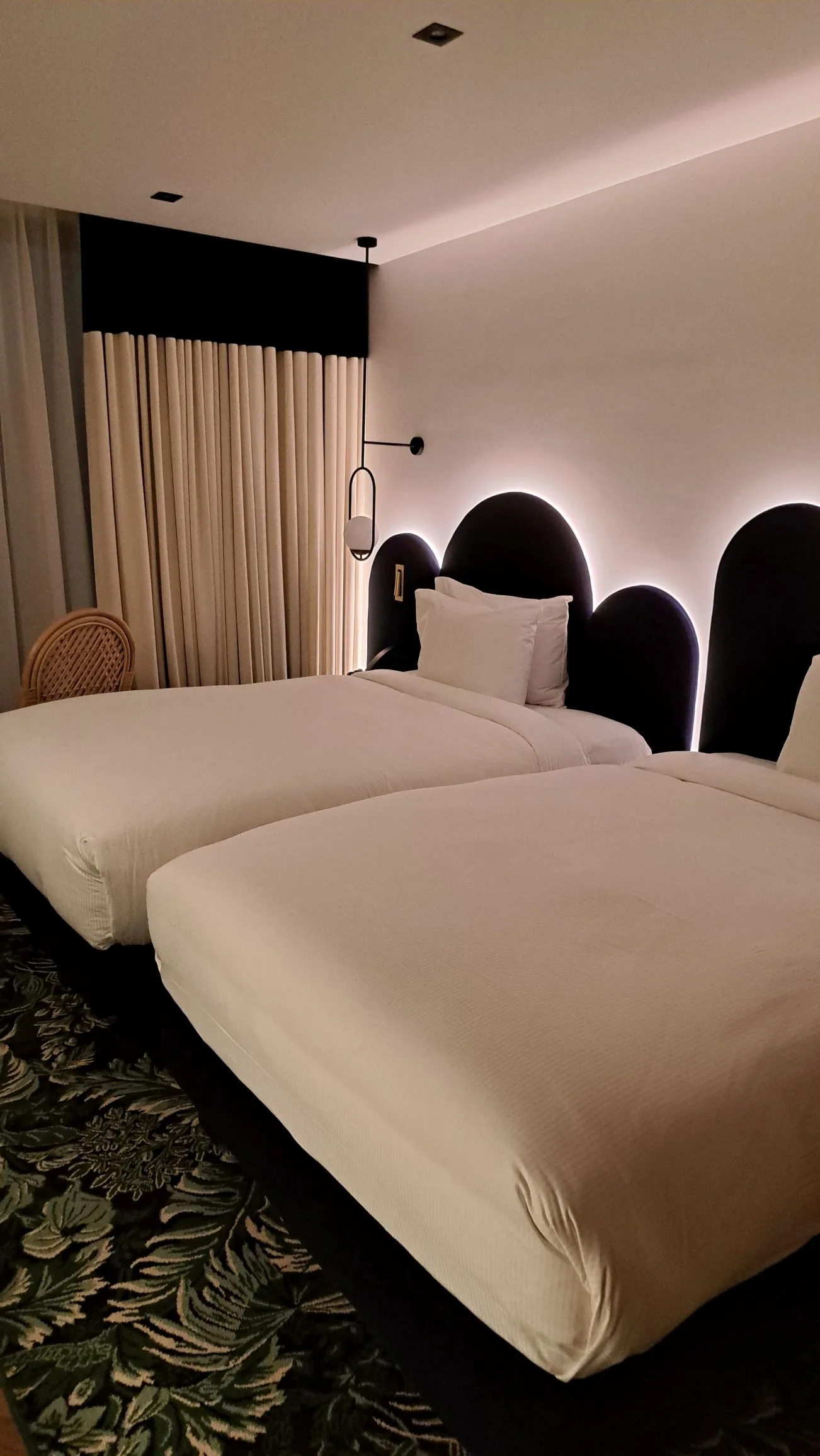 Doppelbett im Hotelzimmer mit beleuchteter Kopfteilverkleidung