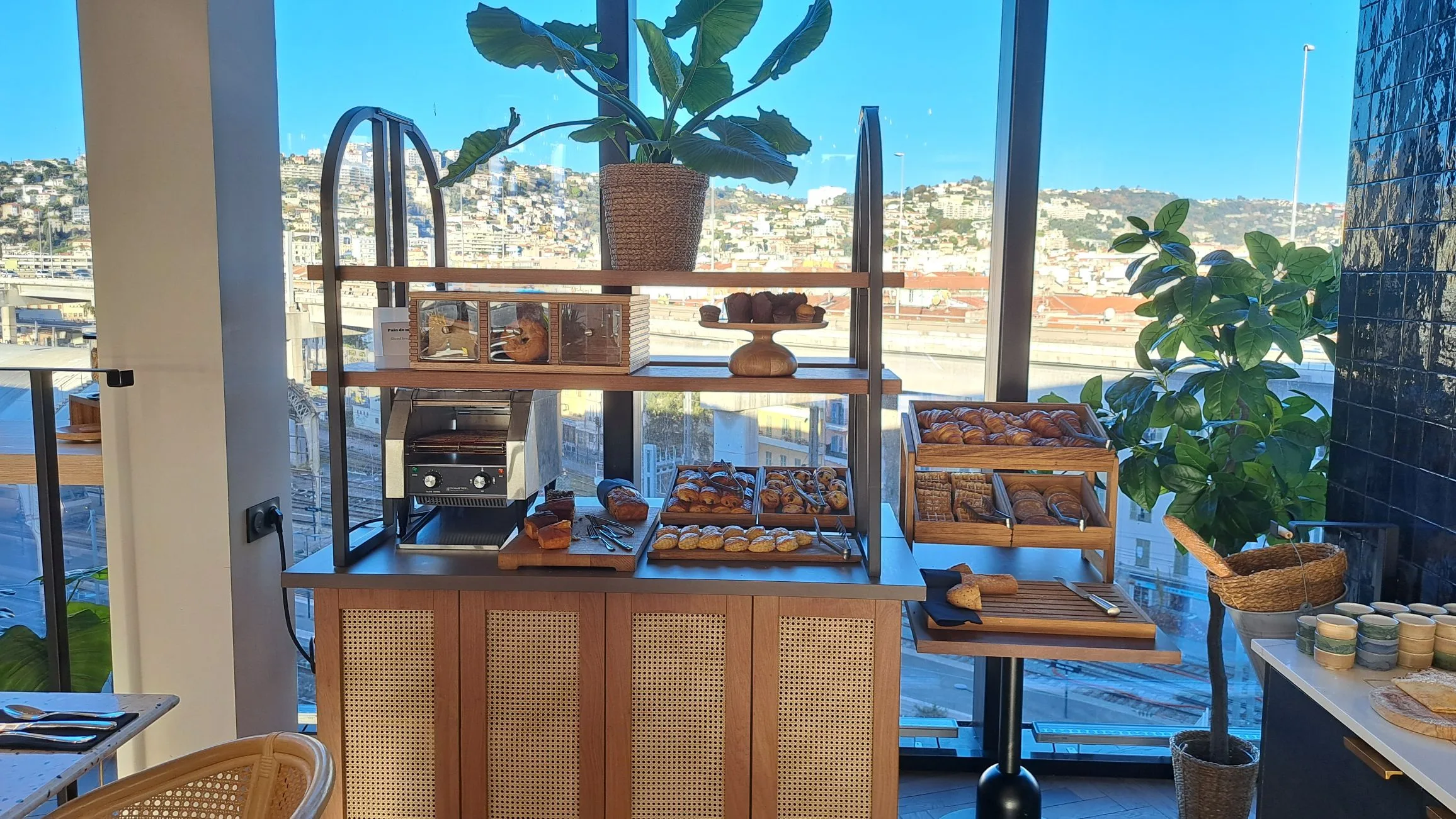 Frühstückstisch mit Kuchen und Brot im Hotel mit Blick auf die Stadt