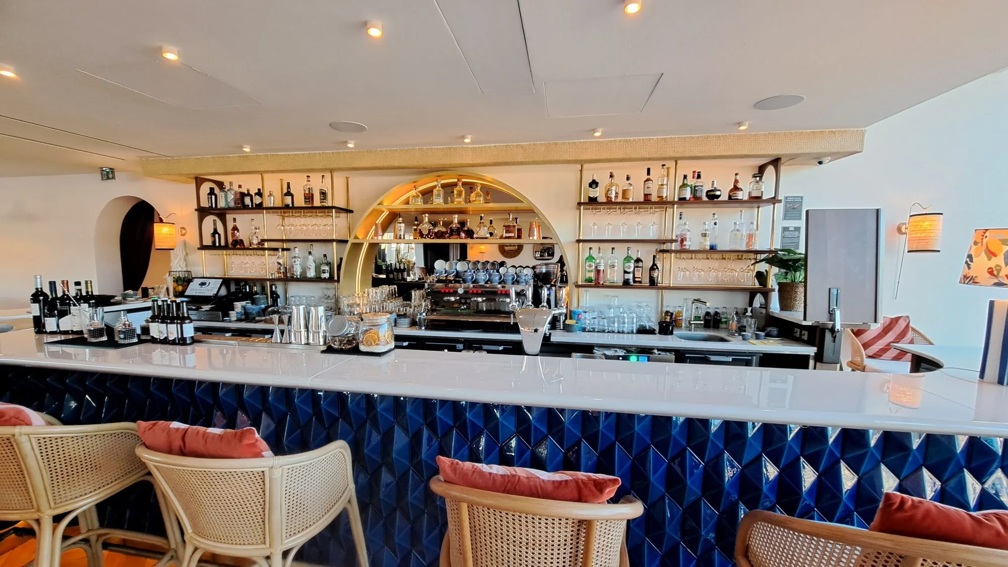Bar mit blauen Fliesen und Holzregalen gefüllt mit Getränken