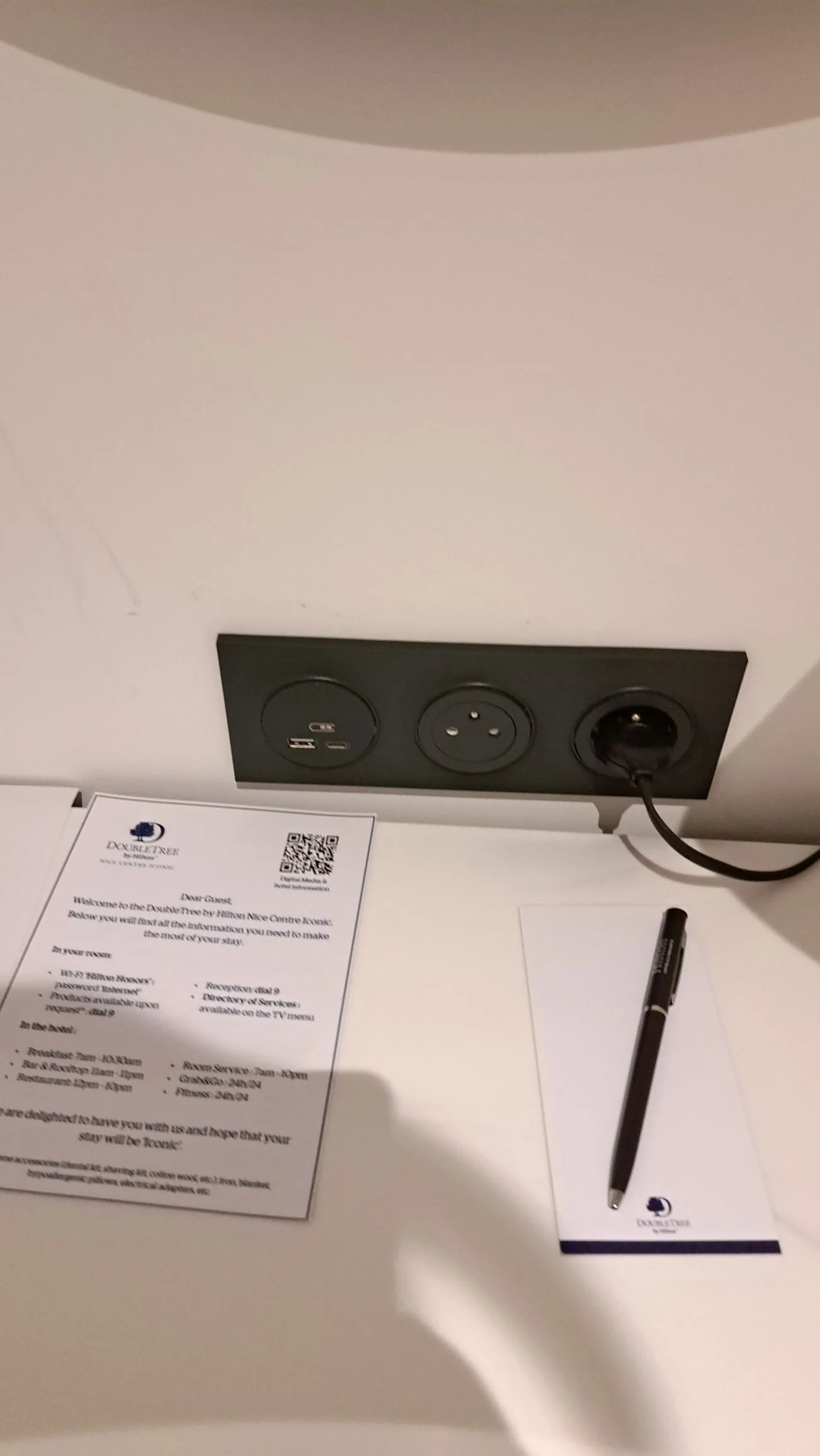 Hotelzimmer mit Steckdose und Dokumenten auf dem Tisch