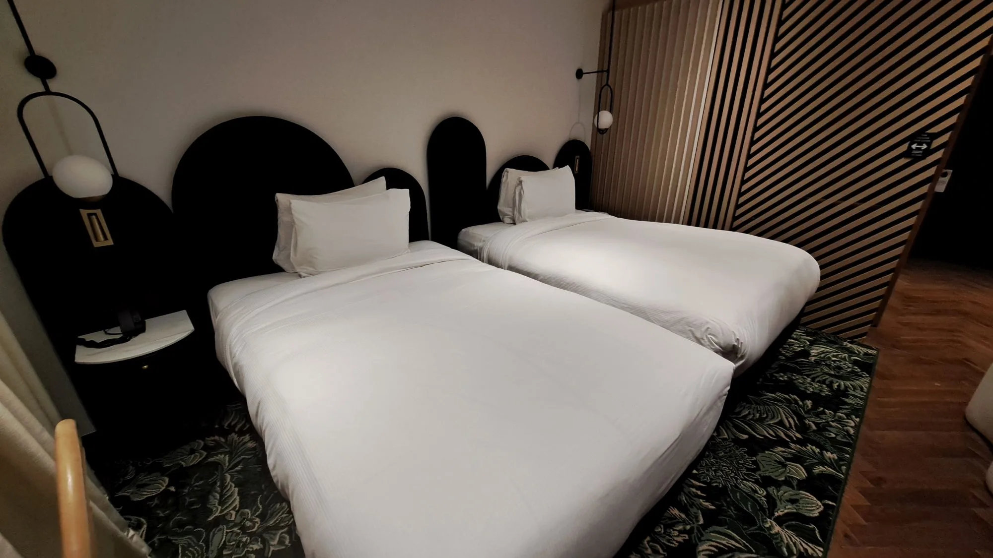 Hotelzimmer mit zwei Einzelbetten und dekorativer Wandgestaltung