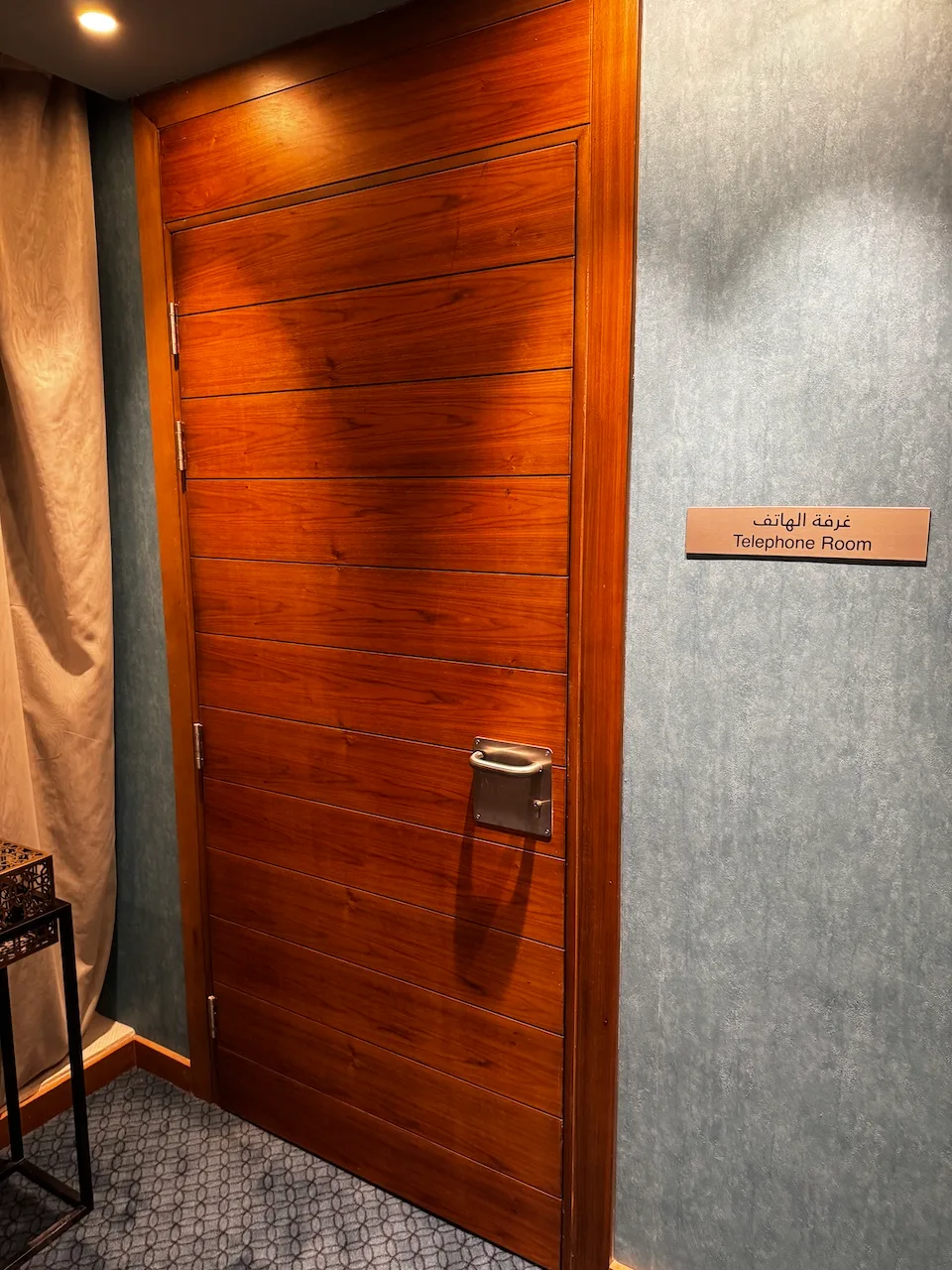 Holztür mit Schild 'Telefonraum' an der Wand
