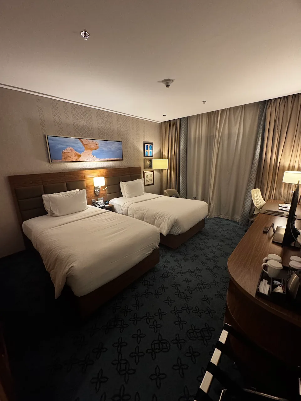 Hotelzimmer mit zwei Einzelbetten und grauem Teppich