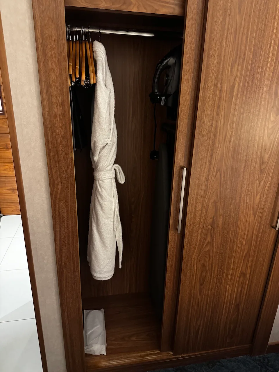 Hölzerne Garderobe mit Kleiderbügeln und Bademantel