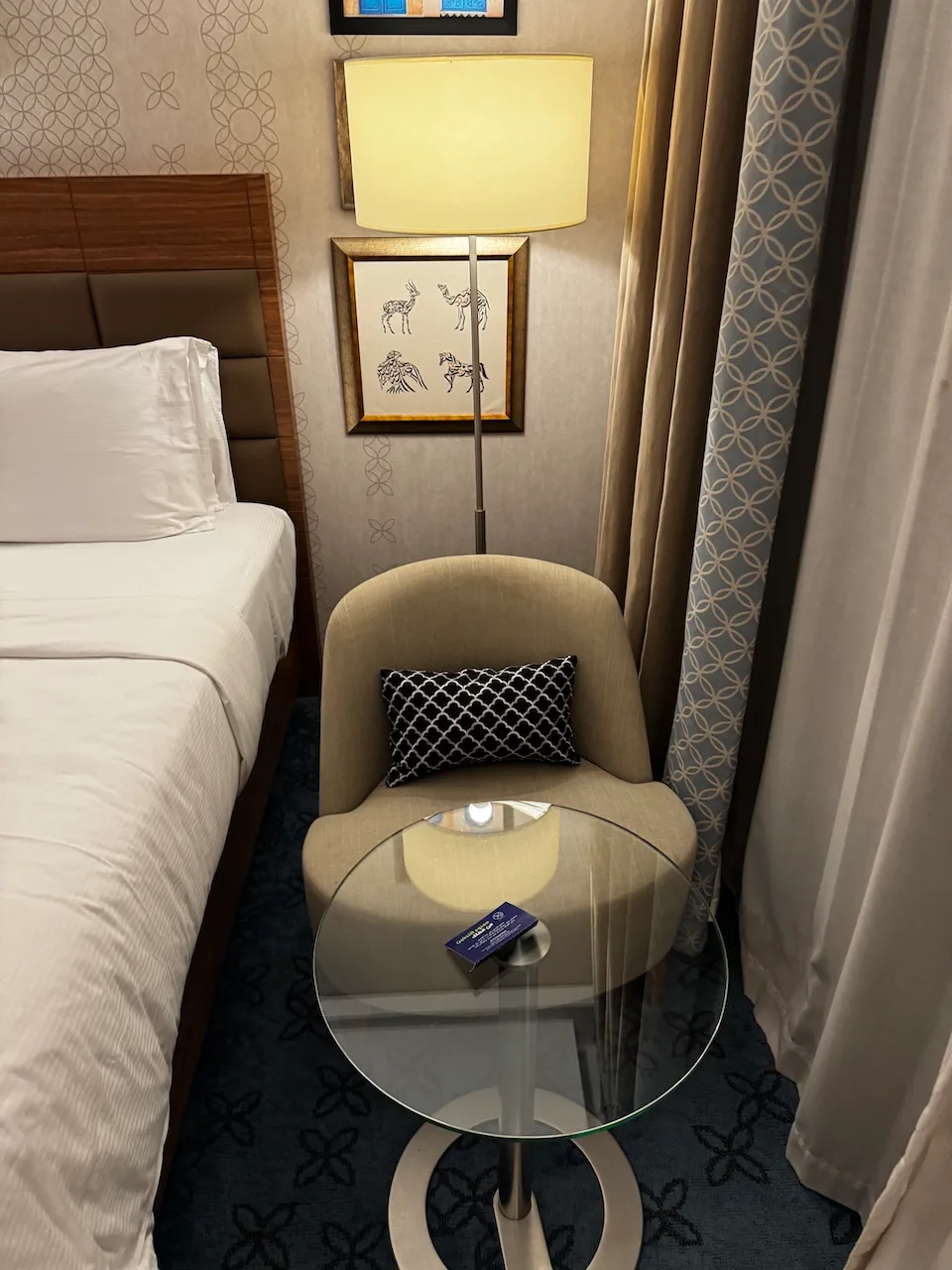 Hotelzimmer mit Doppelbett und Sessel in Grautönen