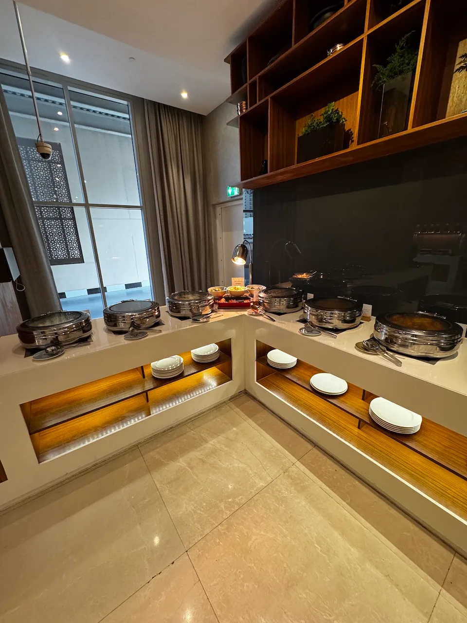 Buffet mit verschiedenen Gerichten und Tellern auf Holzregalen