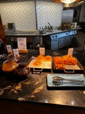 Frühstückstablett mit Waffeln und Sirup auf Granitarbeitsplatte