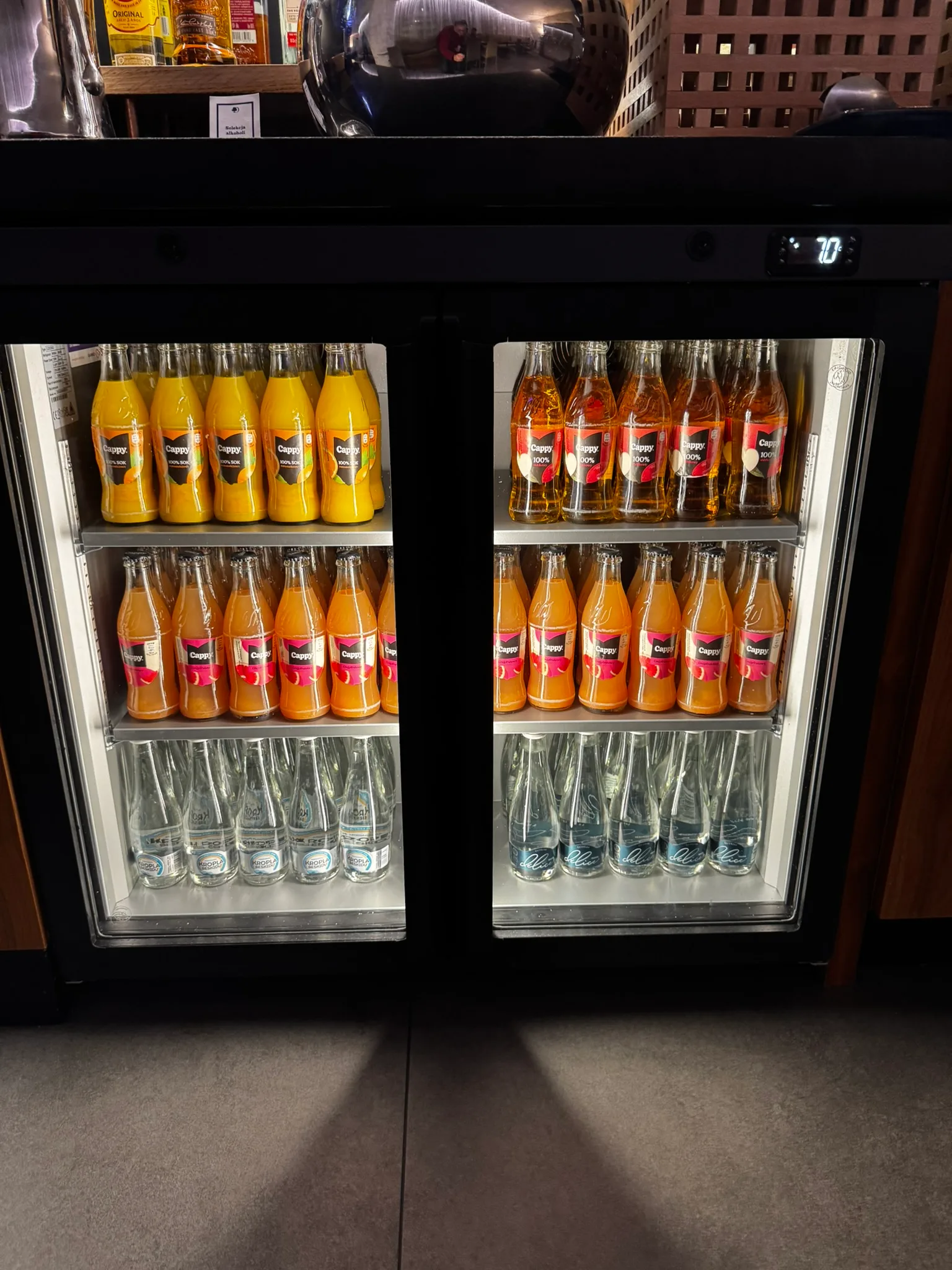 Getränkekühlschrank mit Orangensaftflaschen und Mineralwasser