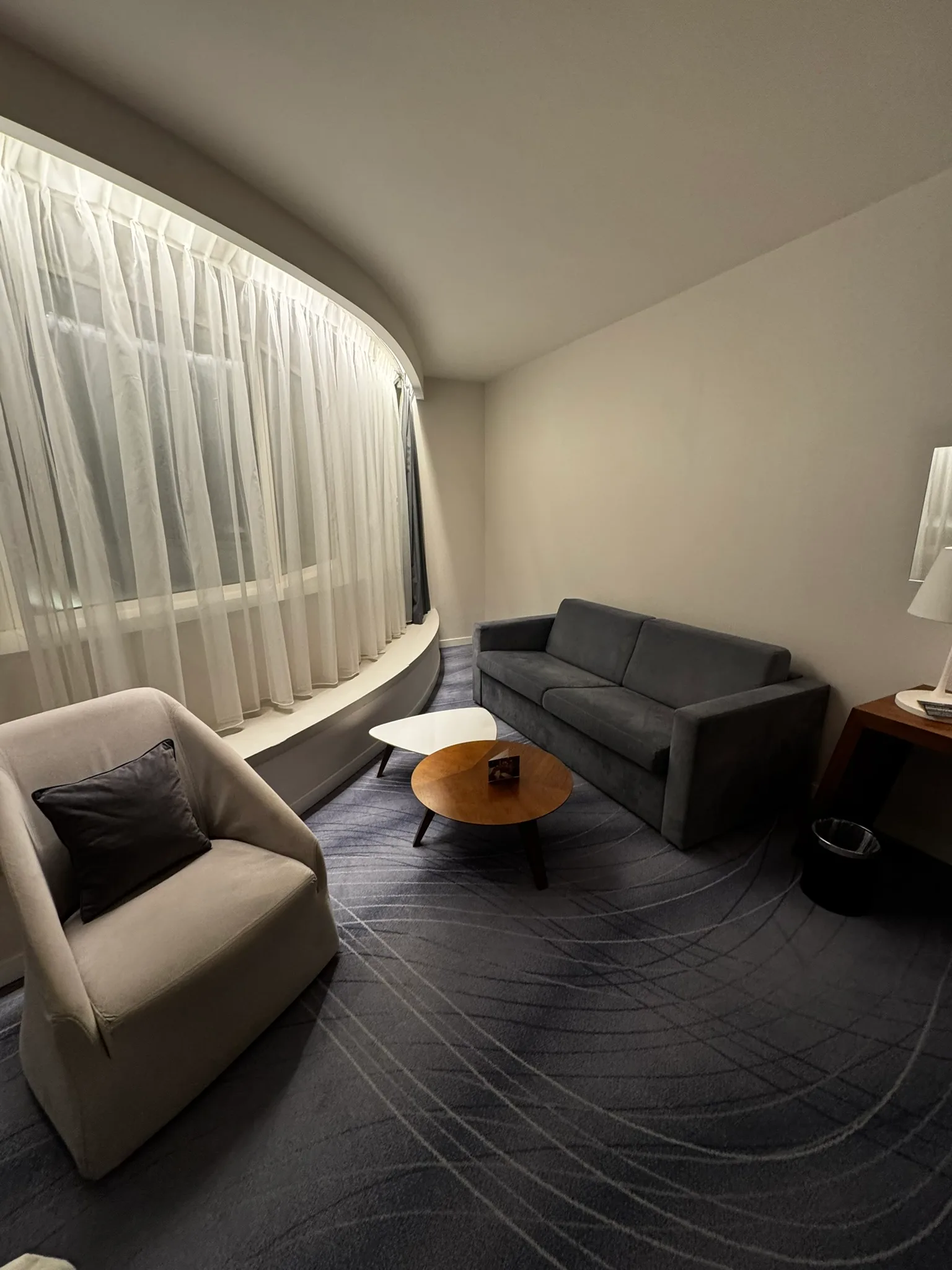 Hotelzimmer mit Couch und Sessel in Grautönen