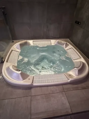 Whirlpool im Hotelbad mit bläulichem Wasser