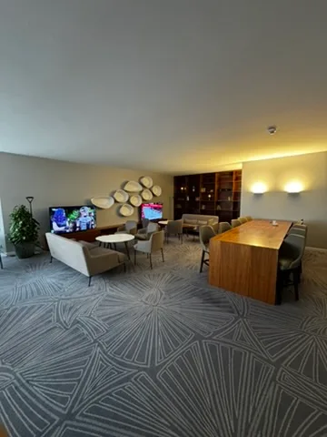 Hotellobby mit Couchen, Tischen und Fernseher