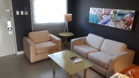Hotellobby mit Sessel und Couch in neutralen Farben