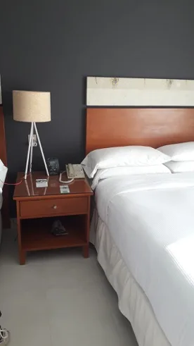 Hotelzimmer mit Doppelbett und Nachttisch in Grautönen