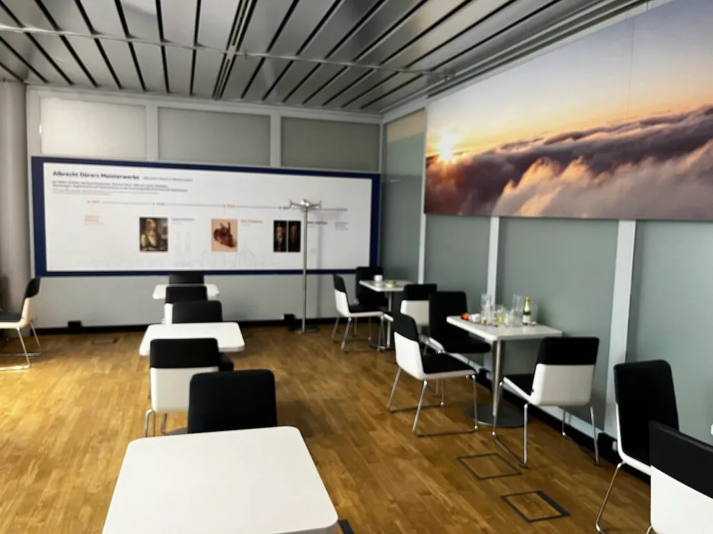 Lounge mit Tischen und Stühlen, Wandbild von Sonnenaufgang