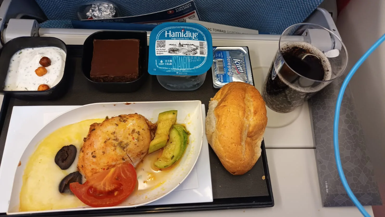 Gedeckter Tisch mit Essen und Getränken auf einem Flugzeugtisch