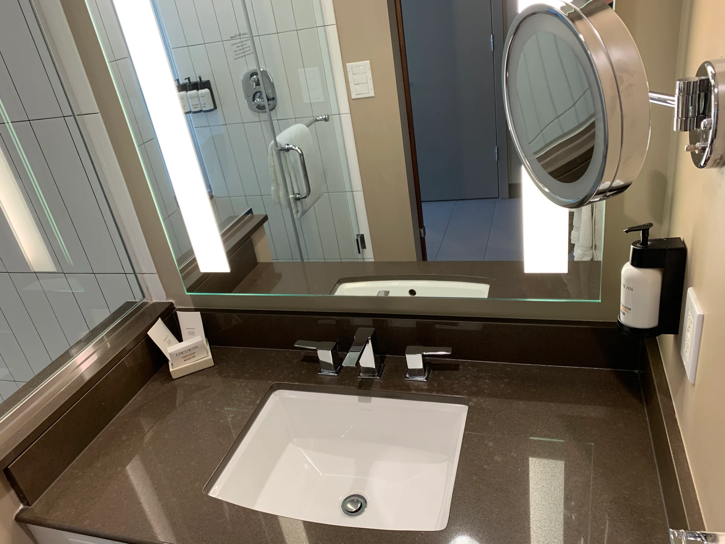 Moderne Badezimmeranlage mit Waschbecken, Spiegeln und Handseife