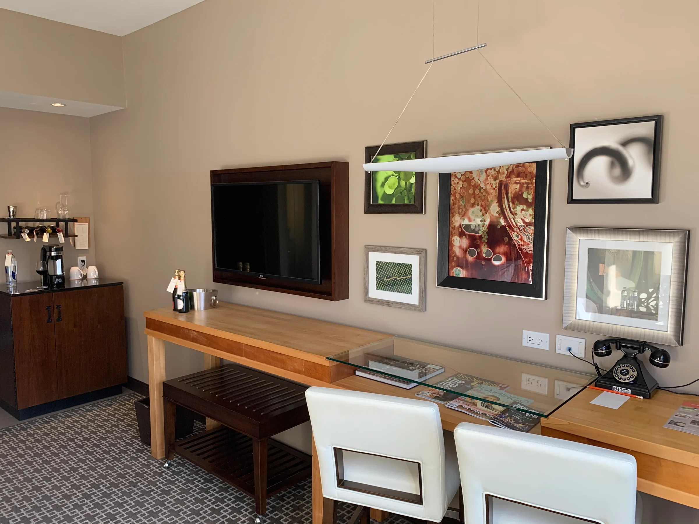 Hotelzimmer mit Schreibtisch, Fernseher und Kunst an der Wand