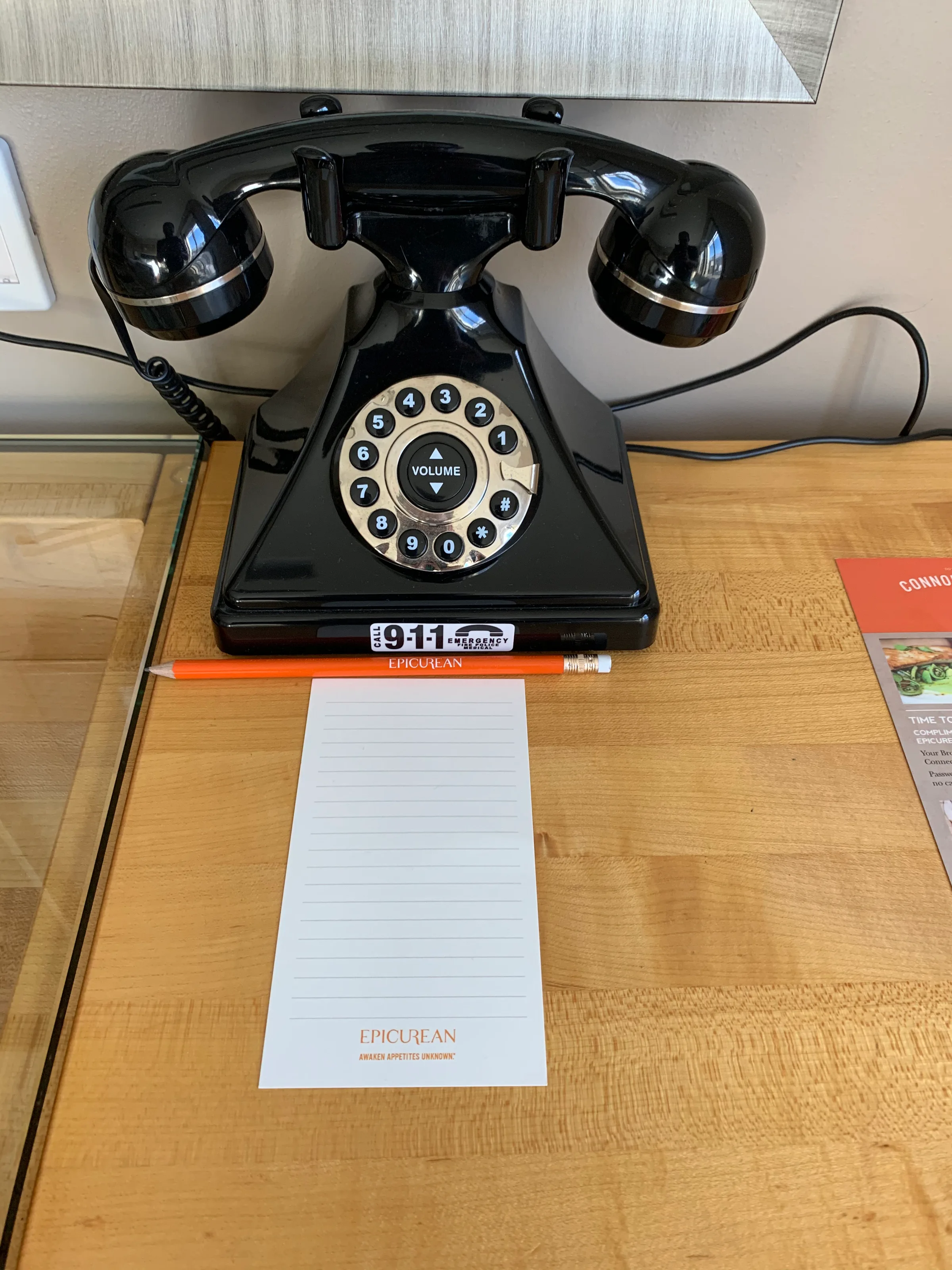 Antikes Telefon auf Holztisch mit Notizblock und Bleistift