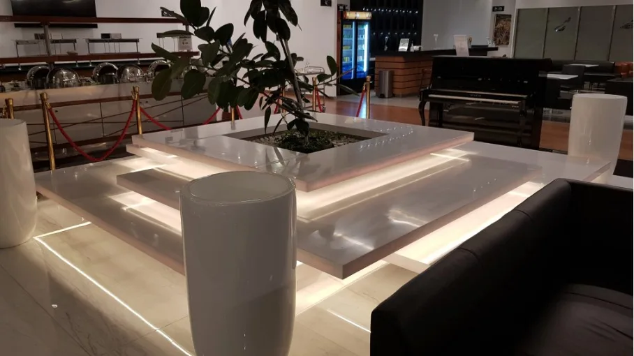 Lounge mit Pflanze und beleuchteten Tischen