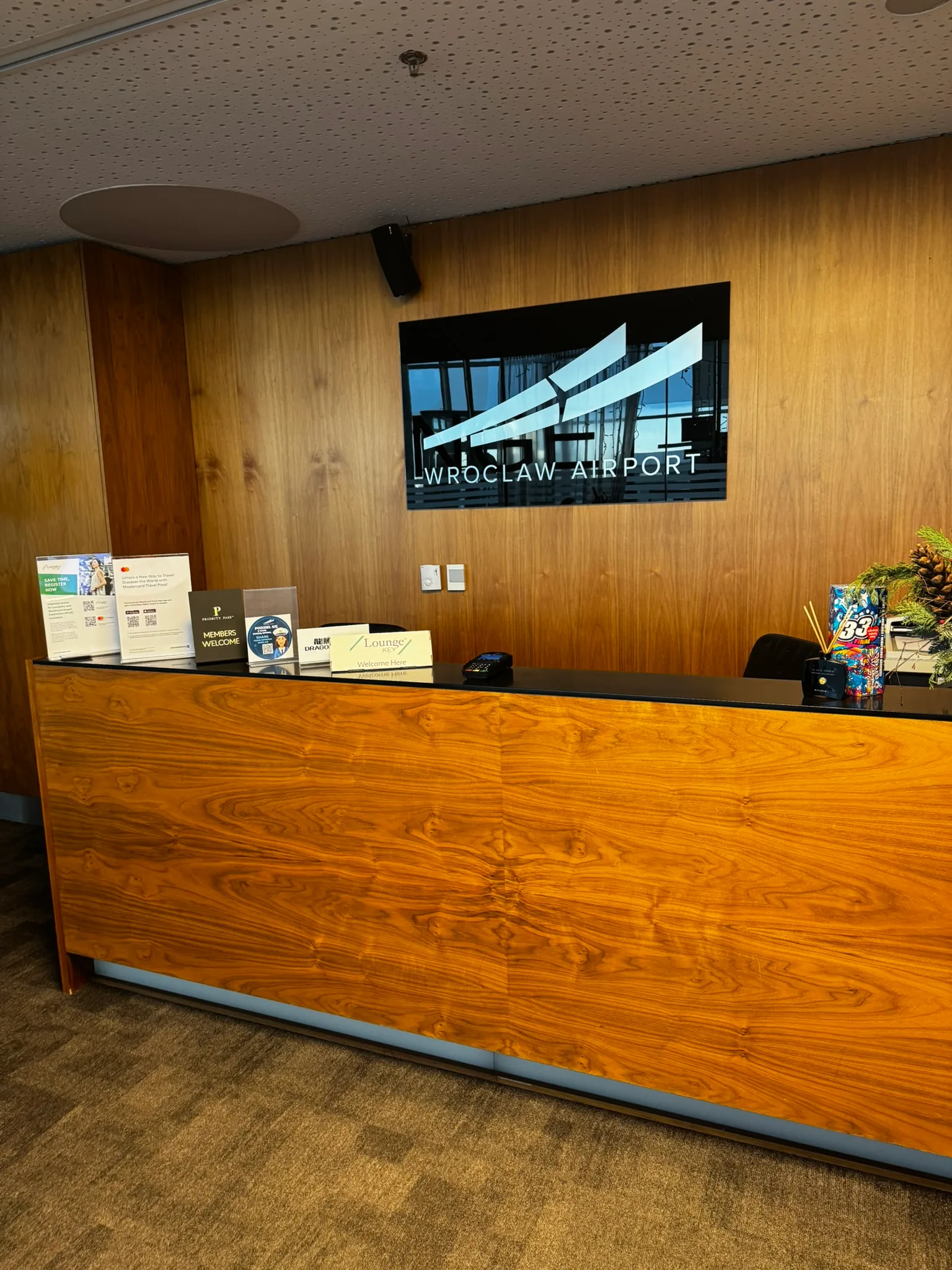 Rezeption des Wrocław Airport mit Holztisch und Werbematerialien