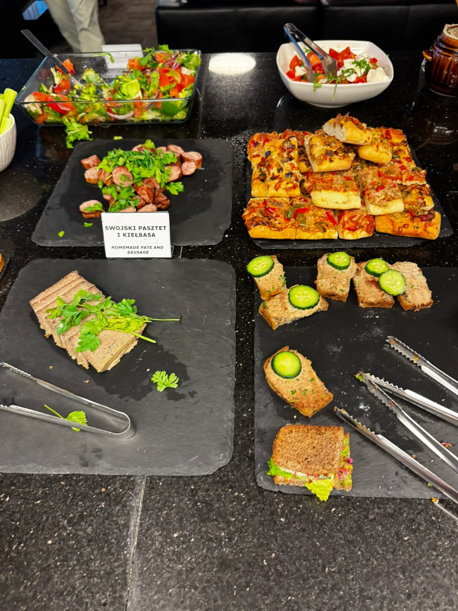 Buffet mit verschiedenen Snacks und Salaten auf Schieferplatten