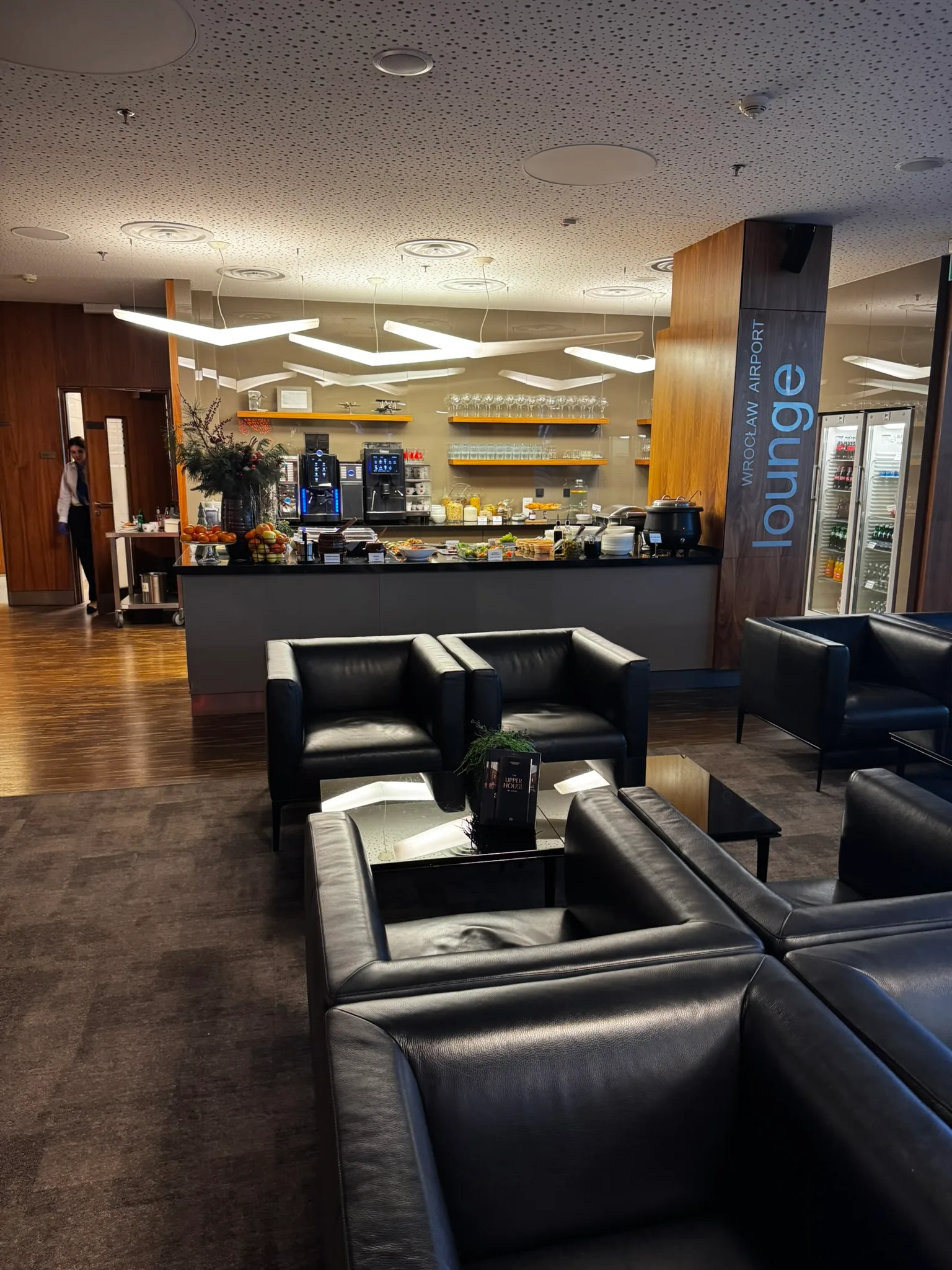 Loungebereich mit Sesseln und Bar im Flughafen Wroclaw